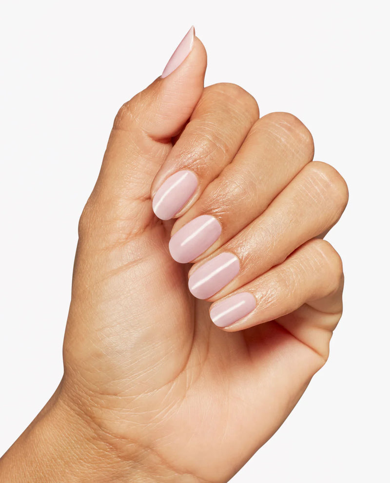 Hand with pink nail polish on a light background